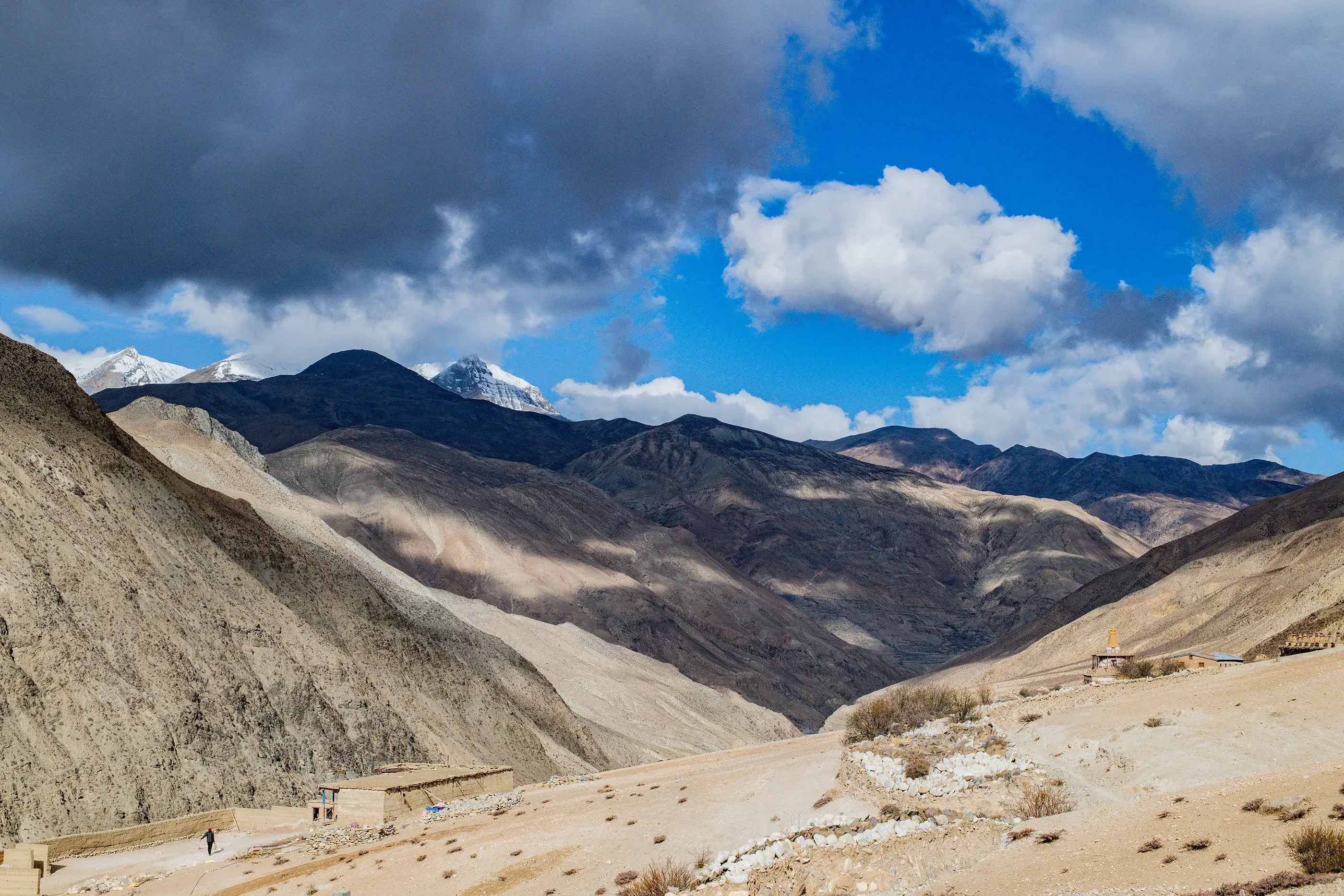 A sandy coloured mountain landscape with blue sky and light grey clouds passing overhead, Dolpa, Nepal.  © WWF Nepal / Sanjog Rai