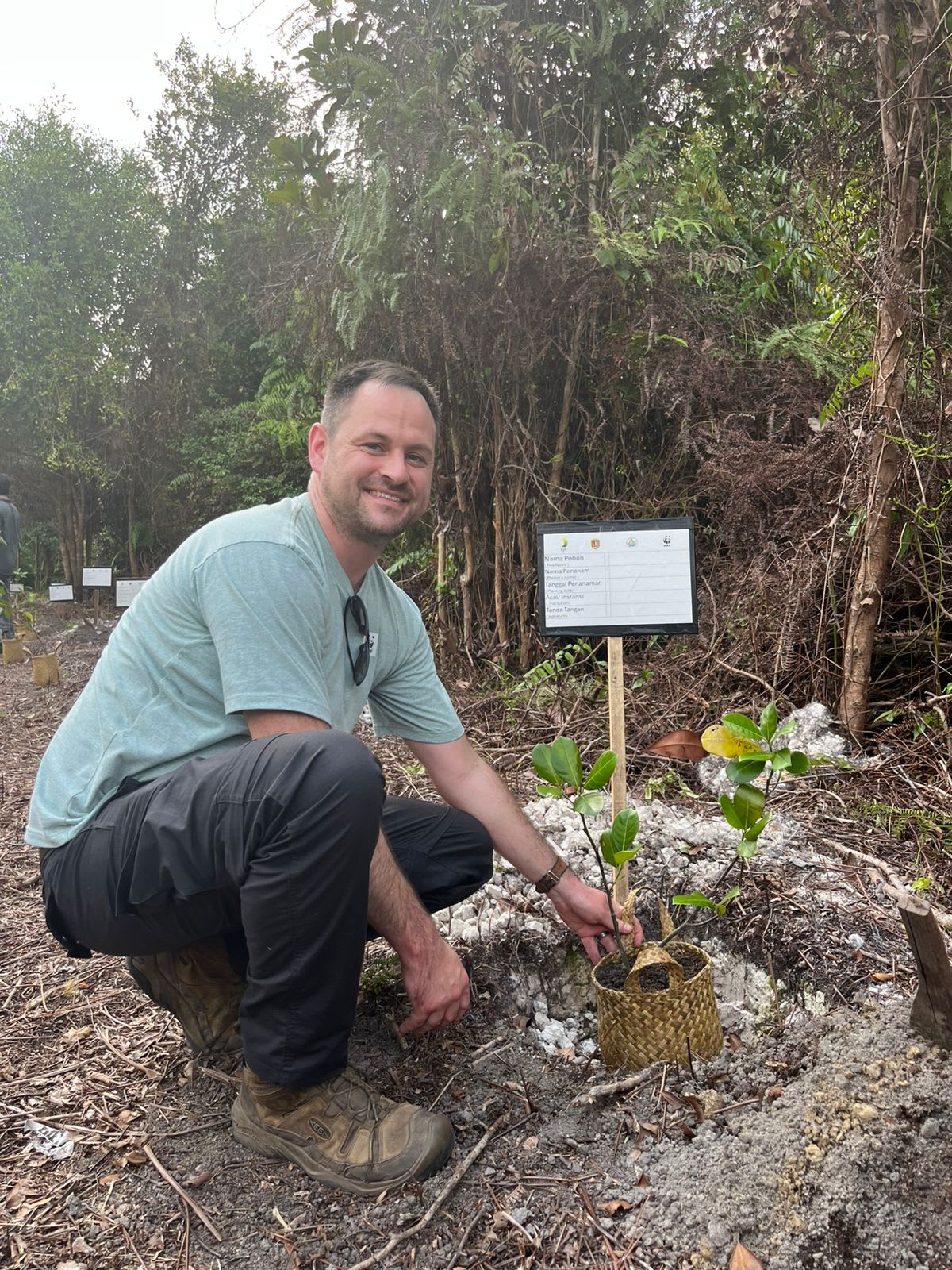 WWF-Australia staff member plants a tree in a forest in Kapakat Atei, Borneo.