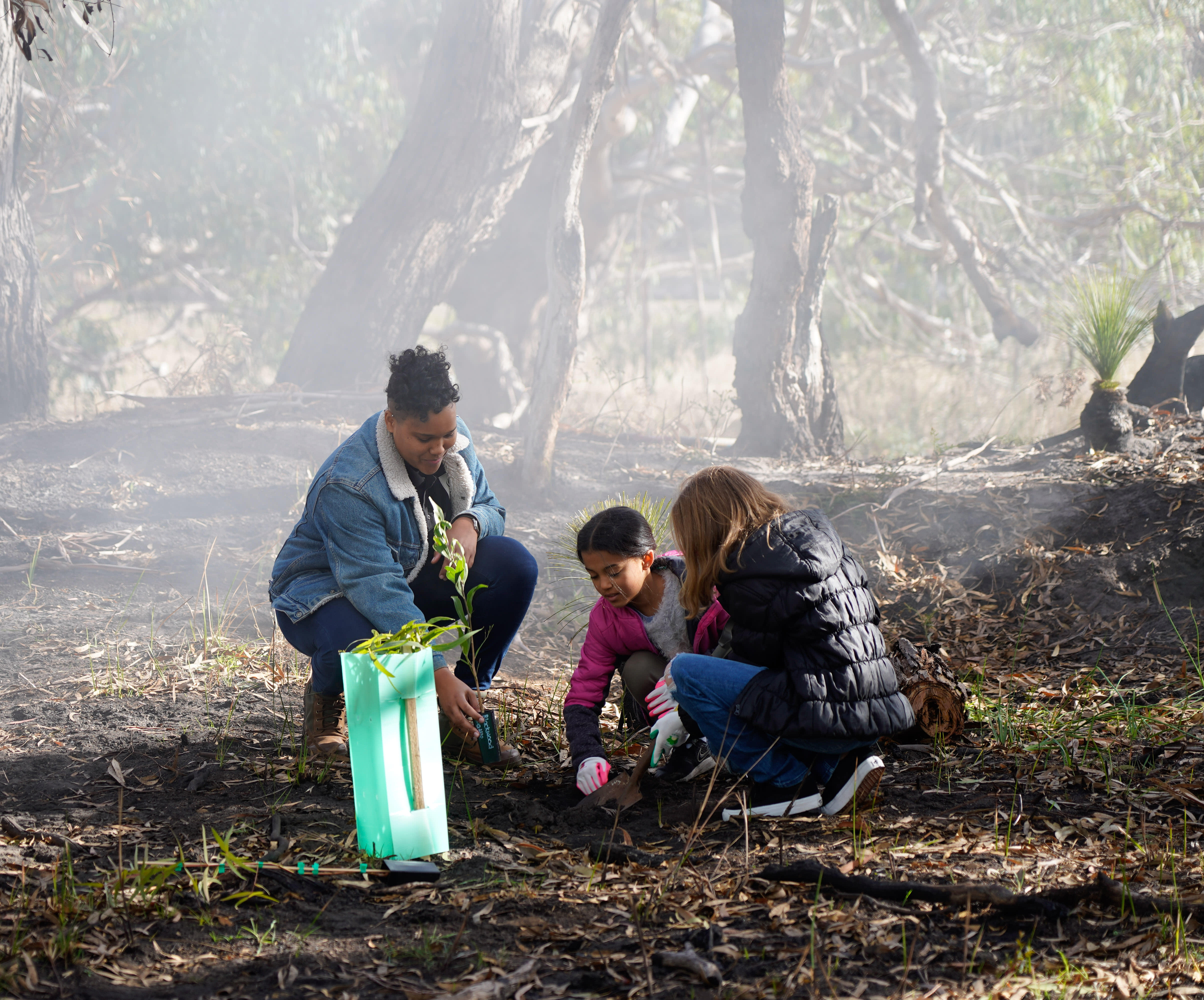 Victoria Pilbeam planting trees with children during Regenerate Australia TV Ad filming