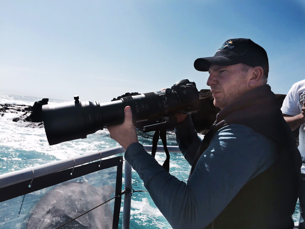 Bequestor and photographer Chris Farrell photographing a pod of dolphins. Seal Rocks, Victoria.