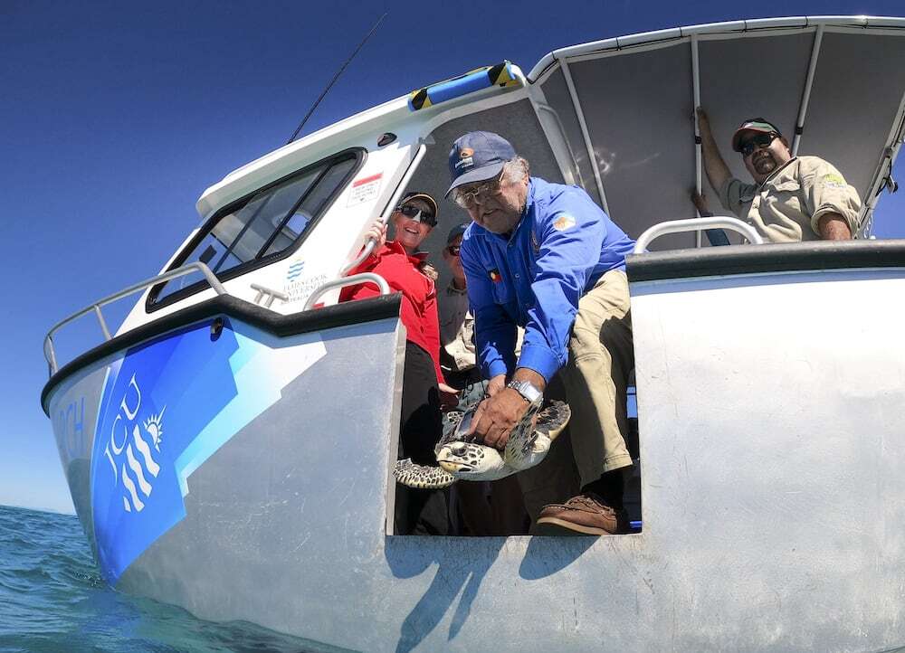 Birri Gubba Juru Elder and Gudjuda senior ranger Jim Gaston releasing hawksbill turtle at John Brewer Reef with James Cook University’s Turtle Health Research staff