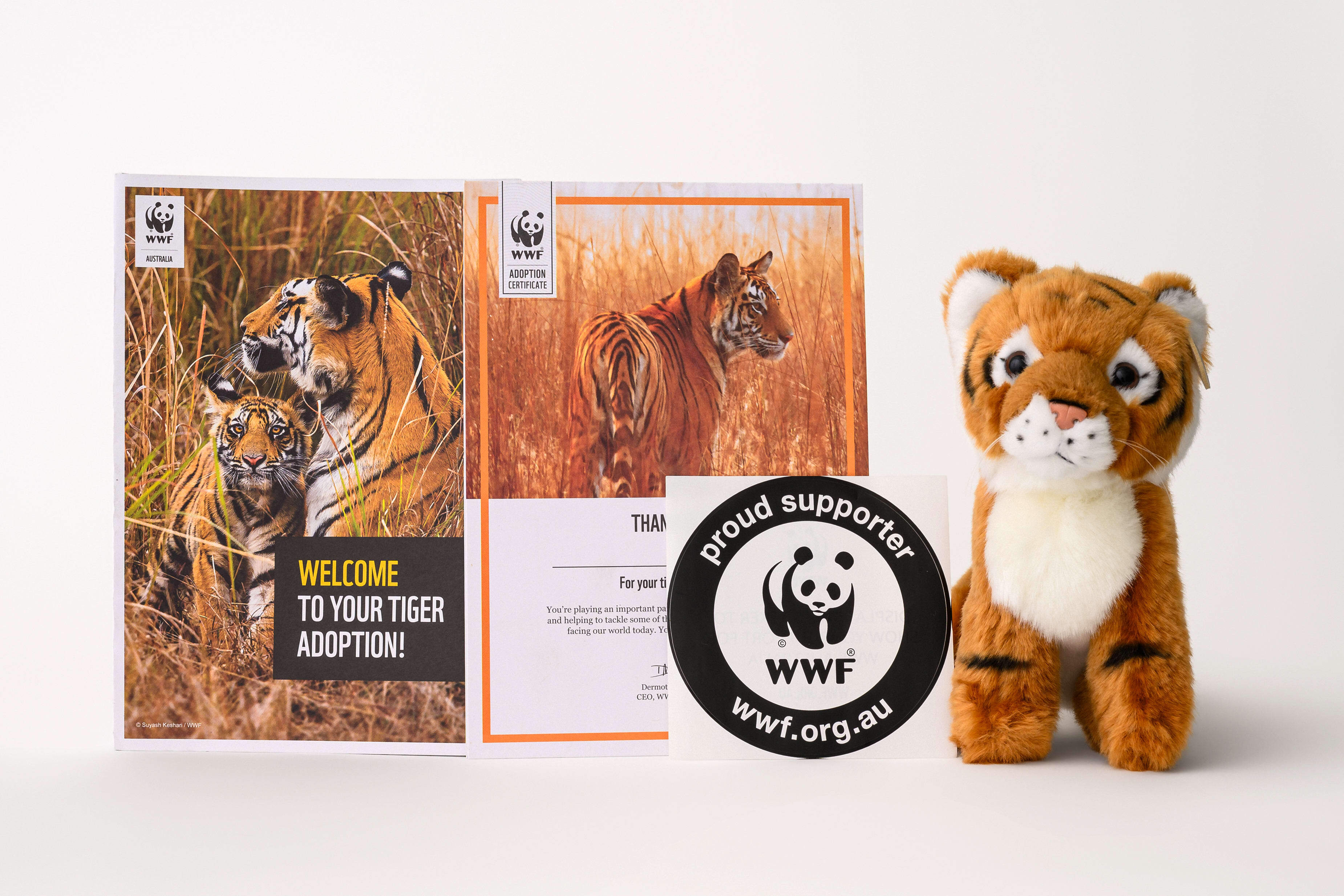 Contents of tiger adoption pack, including tiger plushie, adoption certificate and tiger booklet