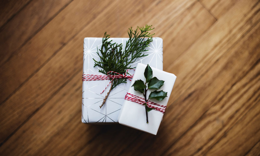 Two Christmas presents tagged with leaves. Photo by Kari Shea on Unsplash