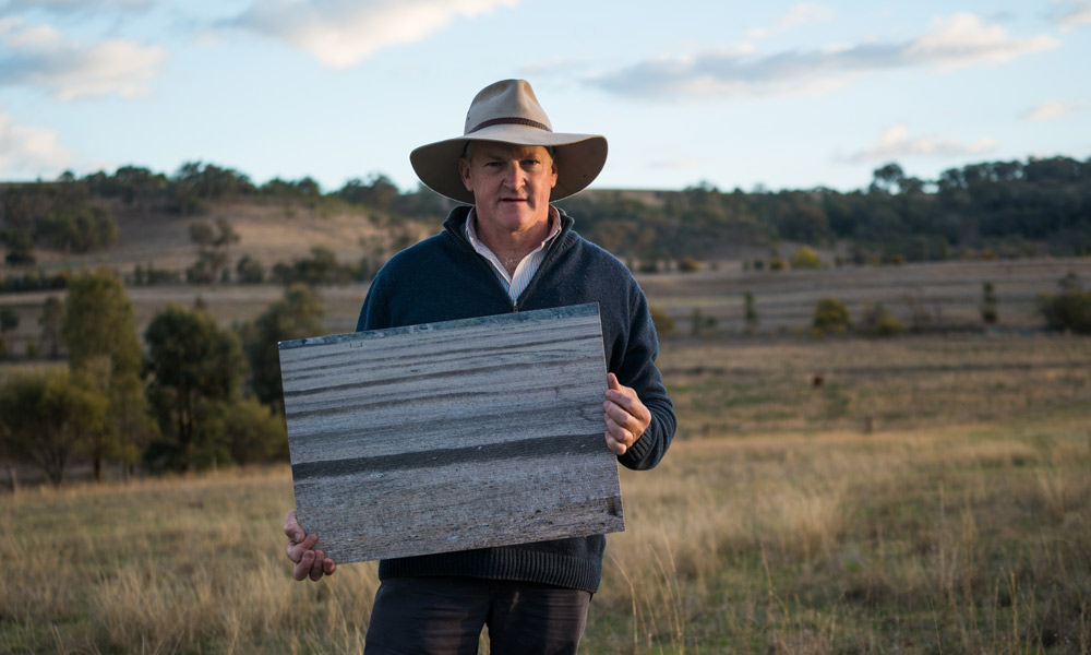 Glenn Morris= General Manager of FigTrees Organic Farms with a poster of what his farm looked like 10 years ago