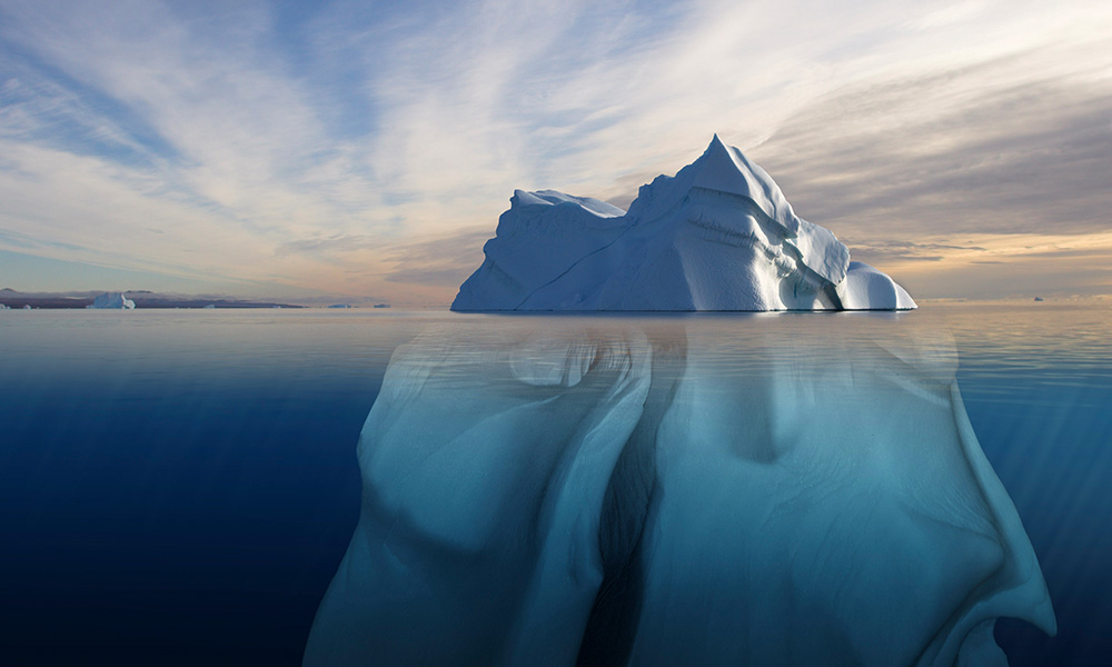 Melting iceberg showing the portion underwater that is sculpted by the sea. Polar regions. Digital composite