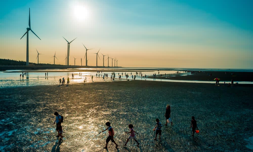 Silhouette of wind turbines at seashore wetland