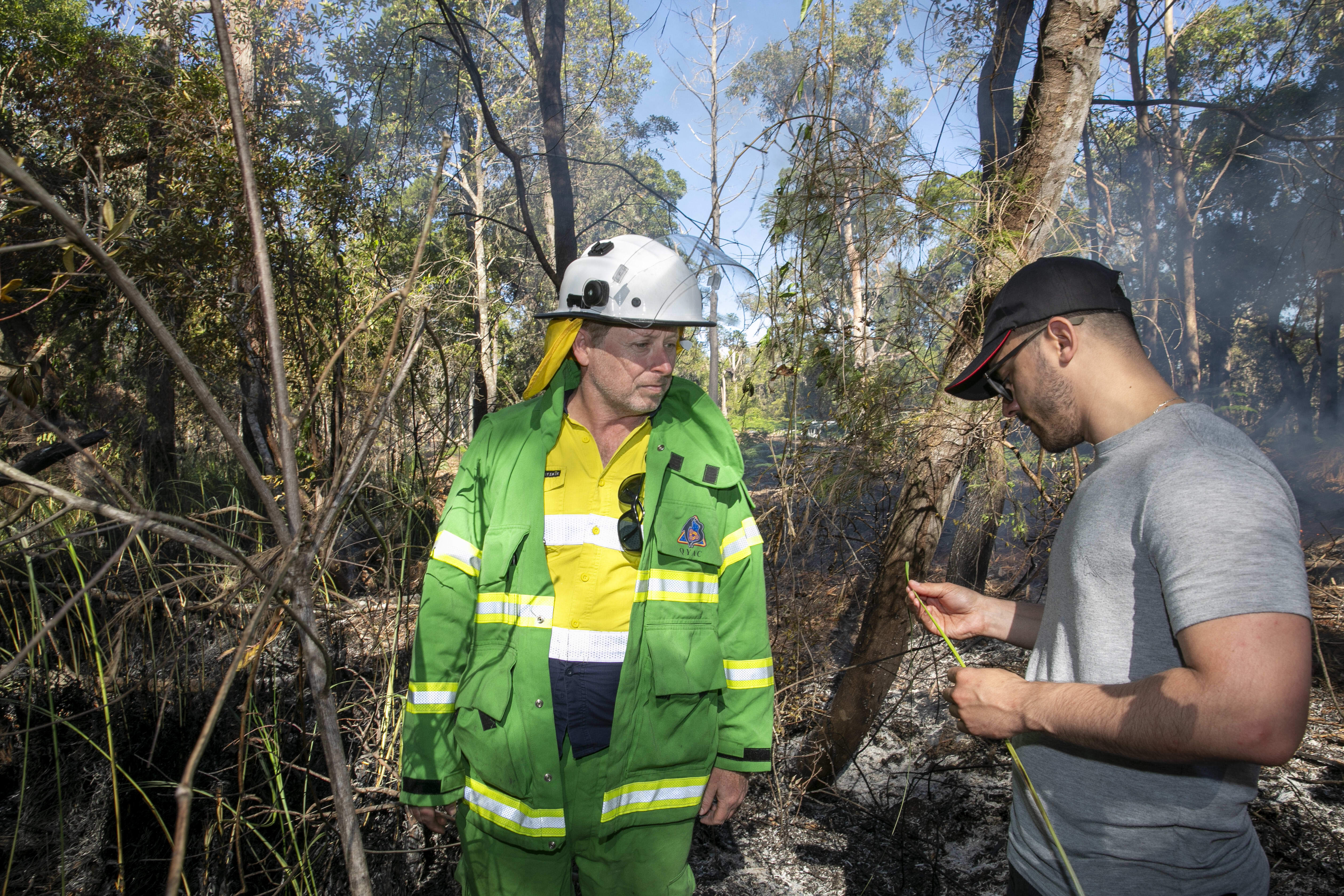 QYAC's Dan Carter and Lucas de Paula from Robotto inspects vegetation post-cultural burn on Minjerribah (North Stradbroke Island)