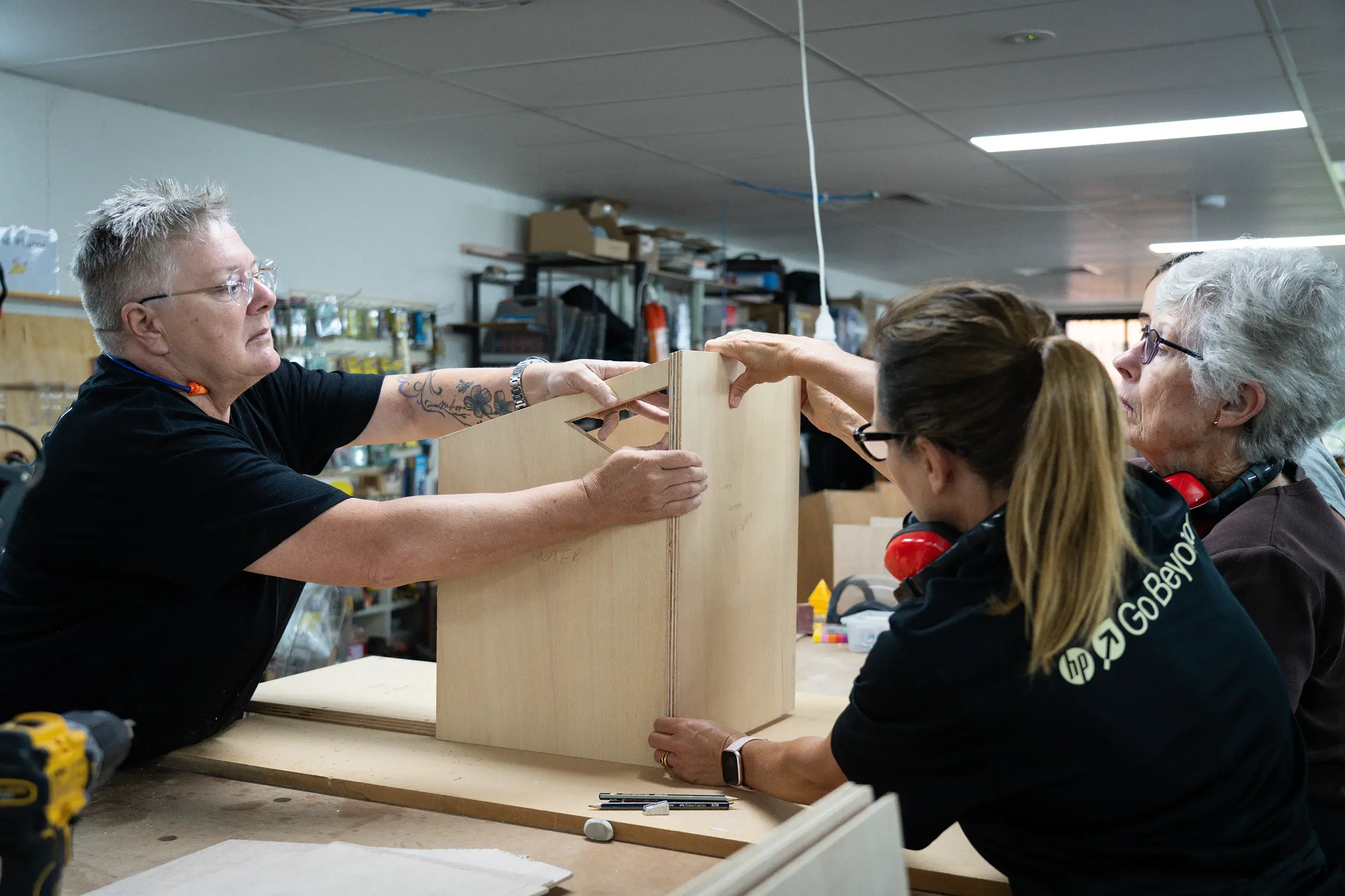 Gill Enterkin (Founder and Head Woodchick) teaches how to construct a nest box in a wood working facility. Construction of greater glider nest boxes with Woodchix in Western Sydney, Australia.