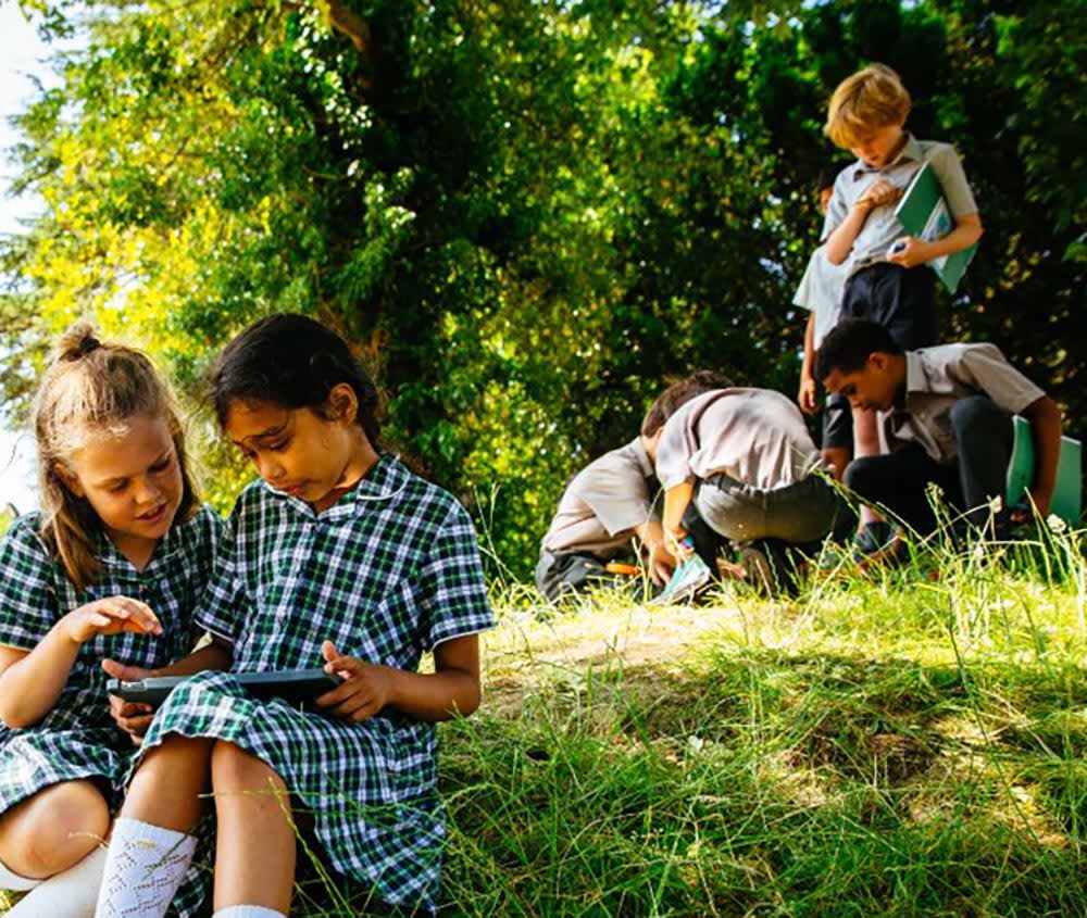 School children sitting outside
