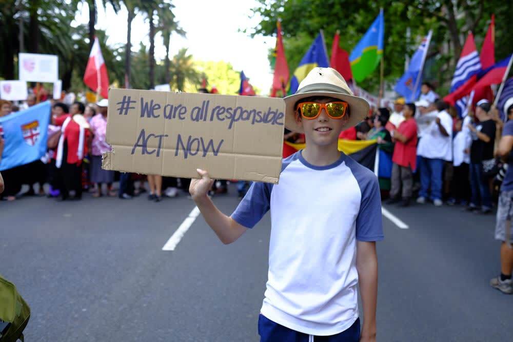 During the People's Climate March, a sign is held asking us to act now