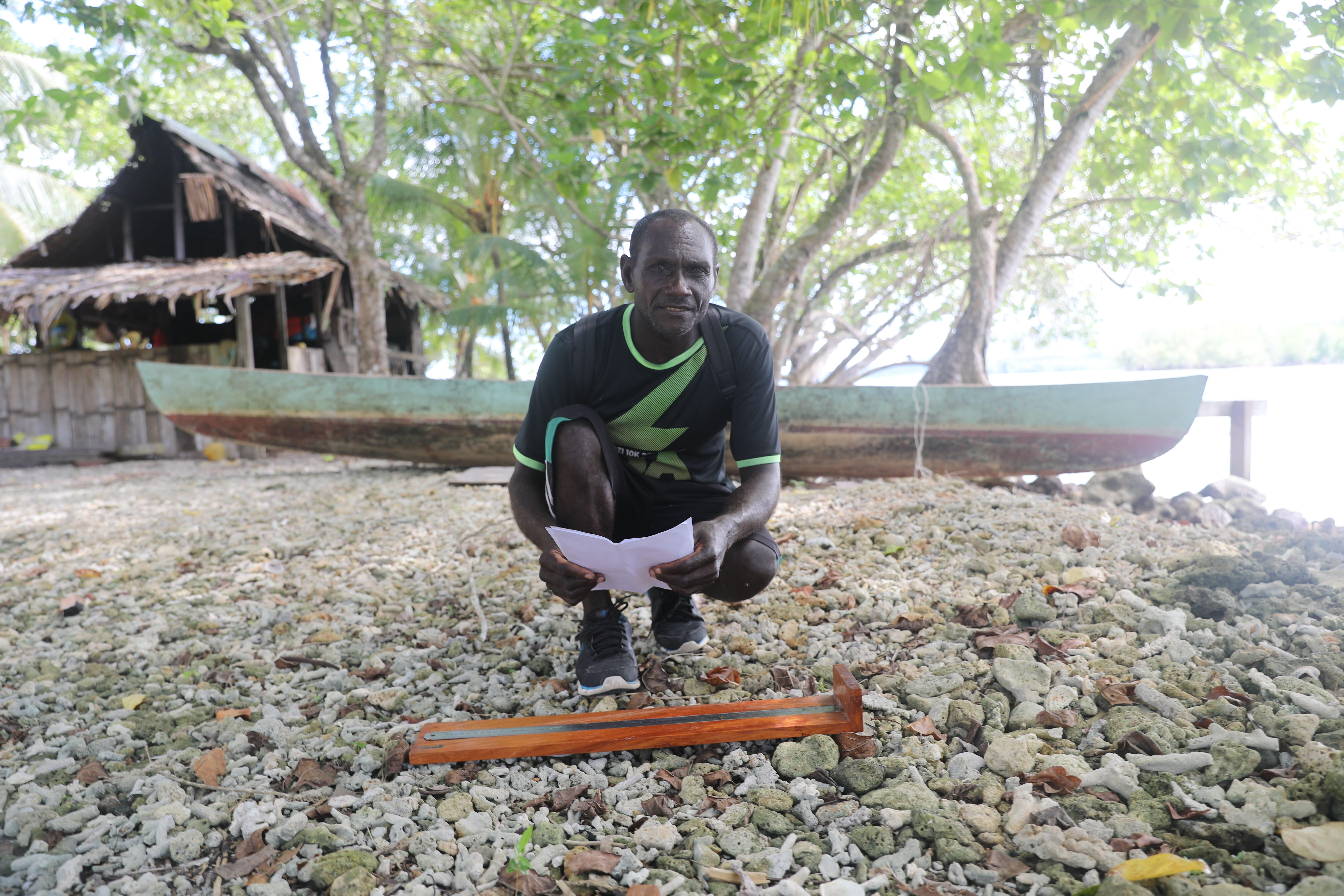 Sese is a local fisherman collecting Spawning Potential Survey (SPS) data using the board WWF helped make for him. By measuring fish against the lengths on the board he is able to help manage the health of the reef for the future.