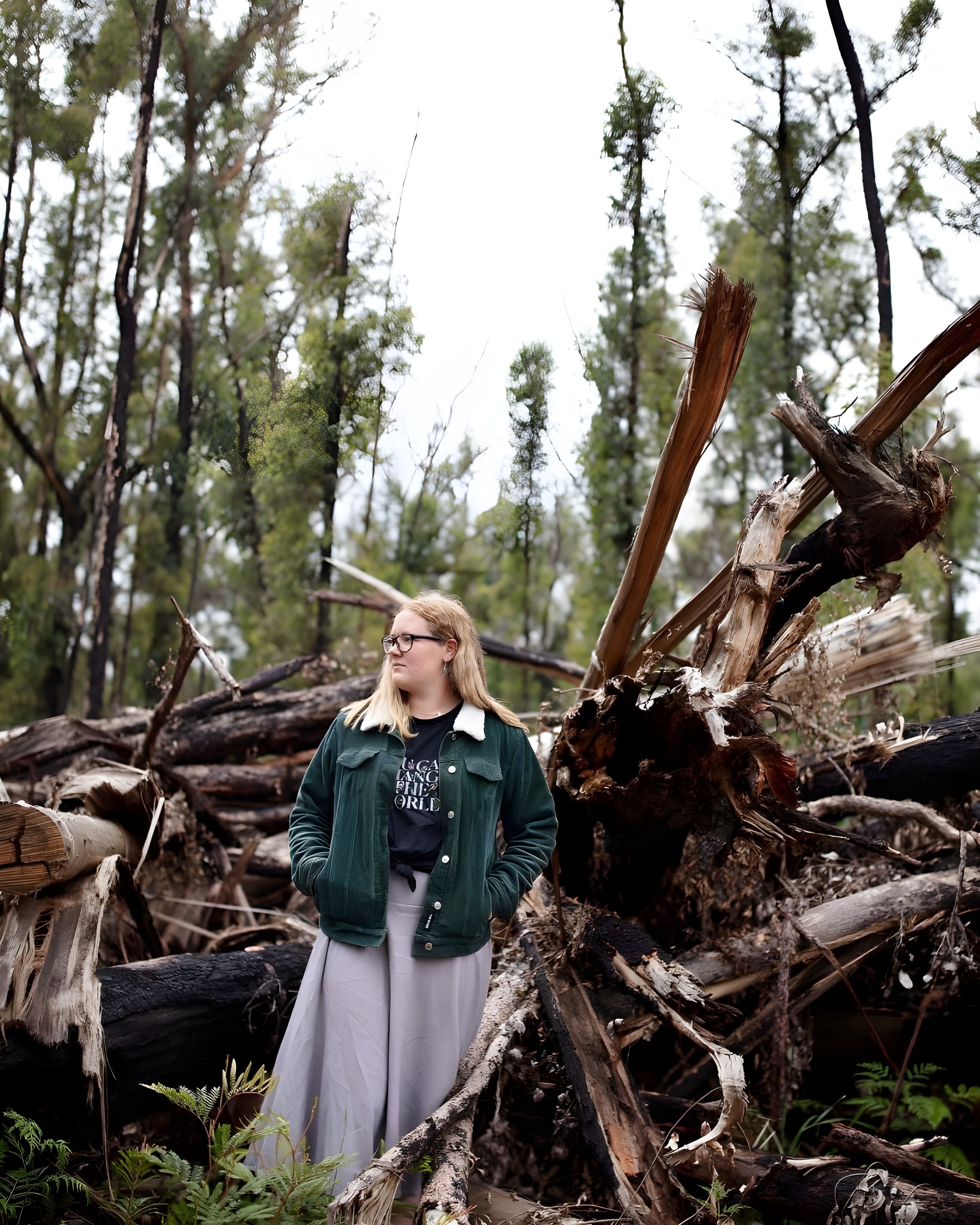2023 Young Environmentalist of the Year Takesa Frank standing in front of forest debris left from logging in North Brooman State Forest.