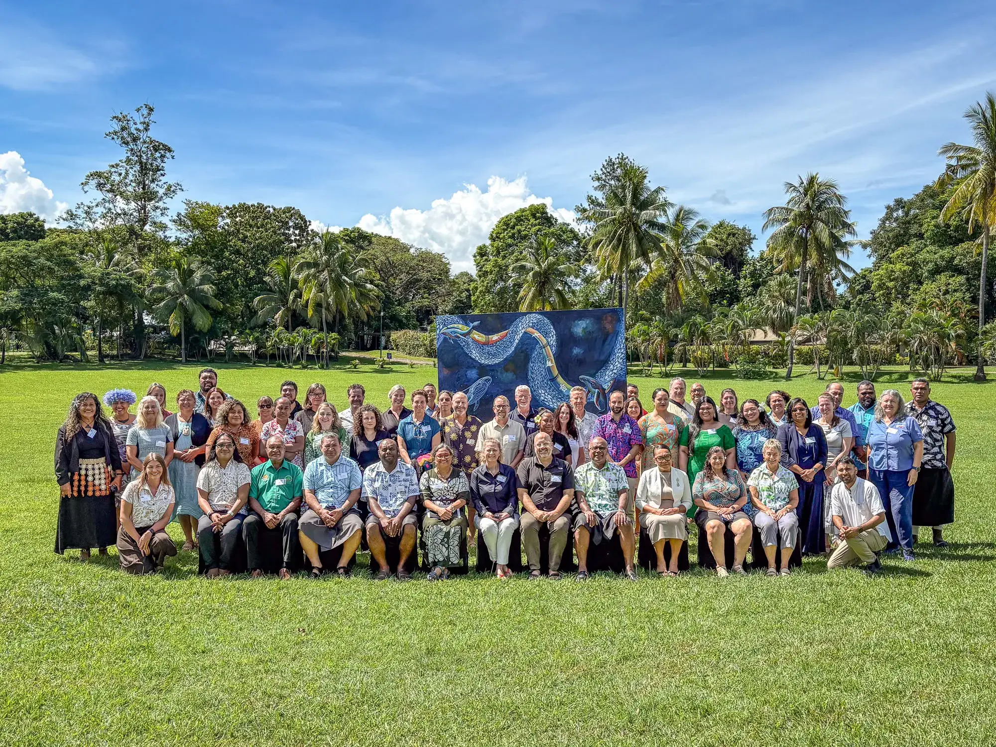 A group photo of WWF Pacific on a grass field with large green trees in background. © WWF-Pacific