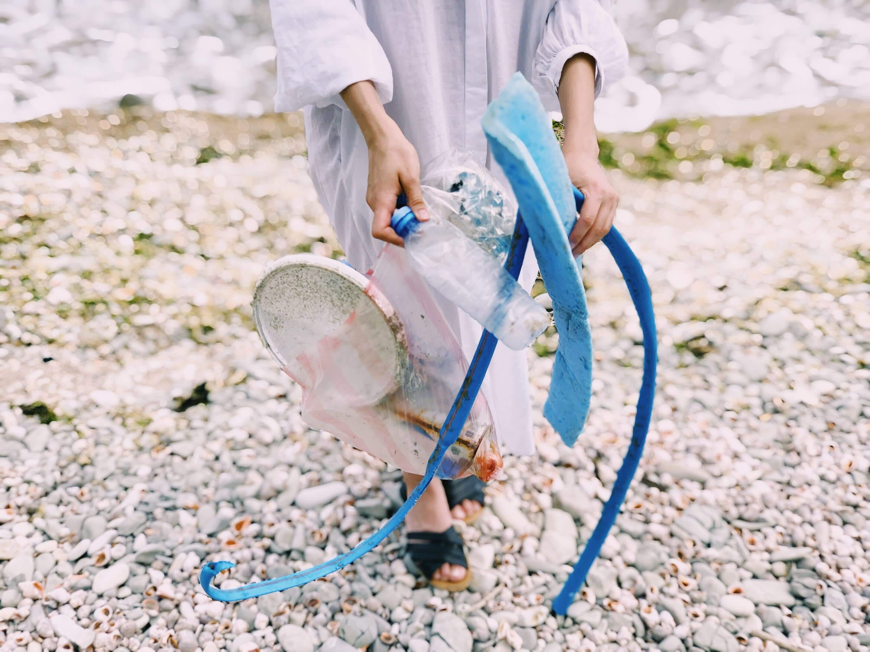 Woman picking up plastics at the beach